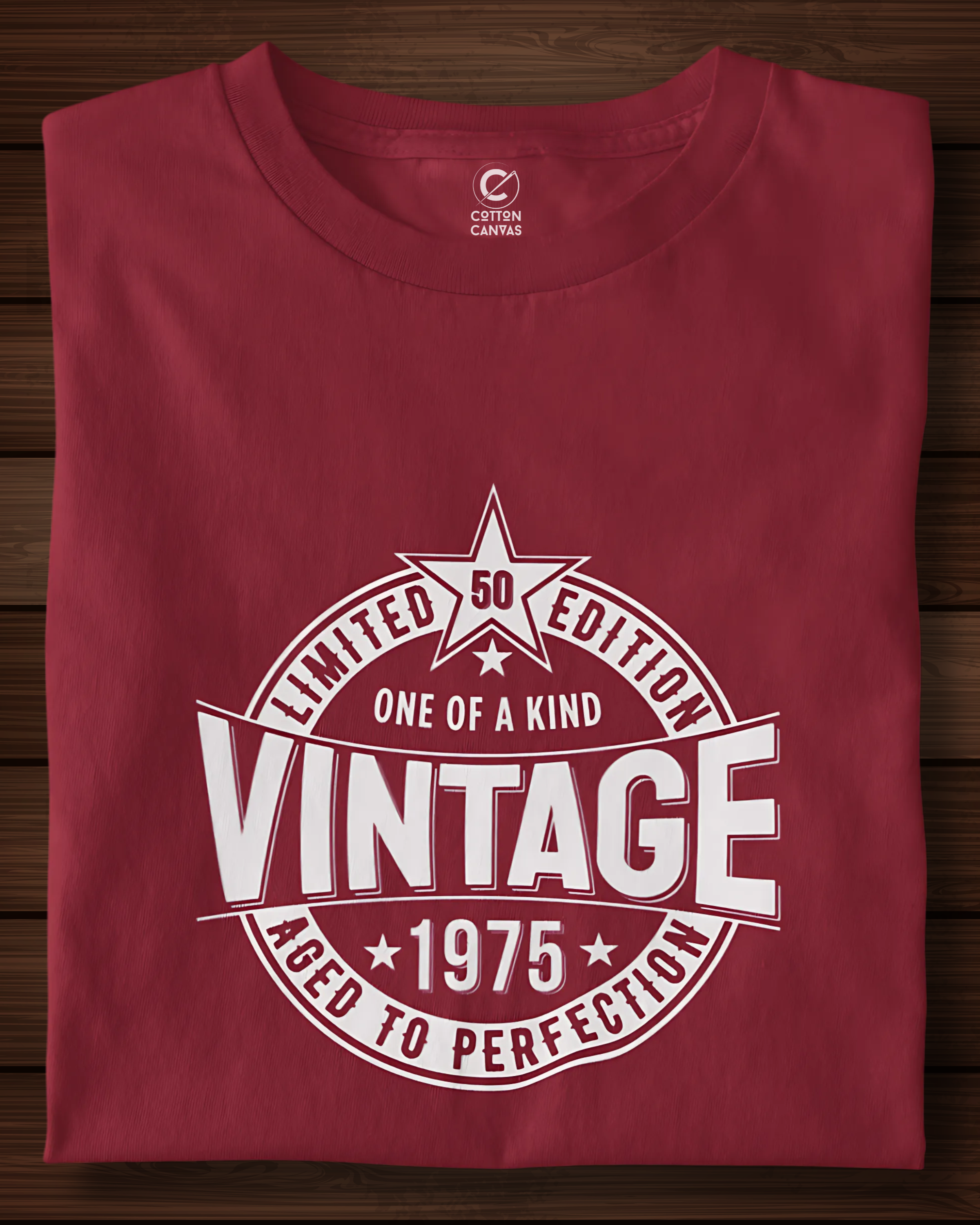 Folded red t-shirt with white graphic design on a wooden surface