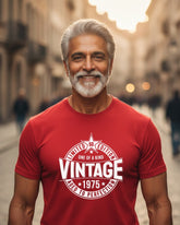 Man wearing a red t-shirt with 'Vintage 1975' design on a street background