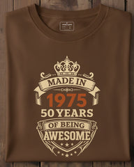 Brown t-shirt with 'Made in 1975, 50 years of being awesome' text on a wooden surface