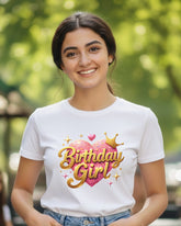 Woman wearing a 'Birthday Girl' t-shirt outdoors with greenery in the background