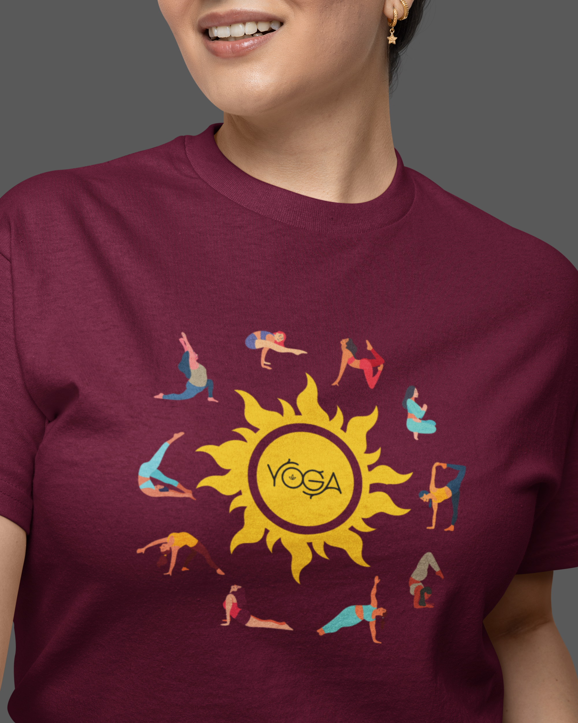 Person wearing a maroon t-shirt with a yoga-themed design featuring a sun and people in various poses.