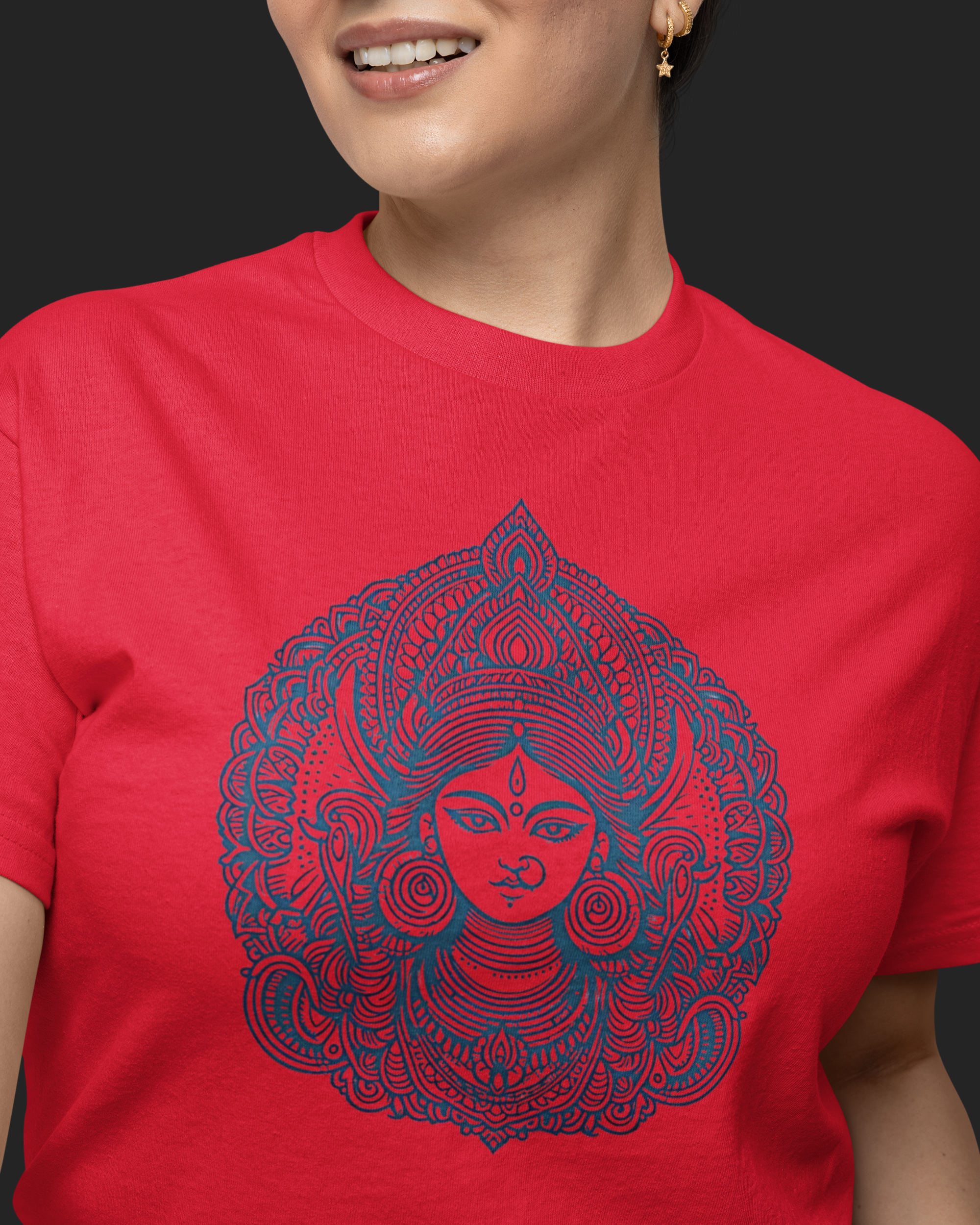 Person wearing a red t-shirt with a blue intricate design on a black background