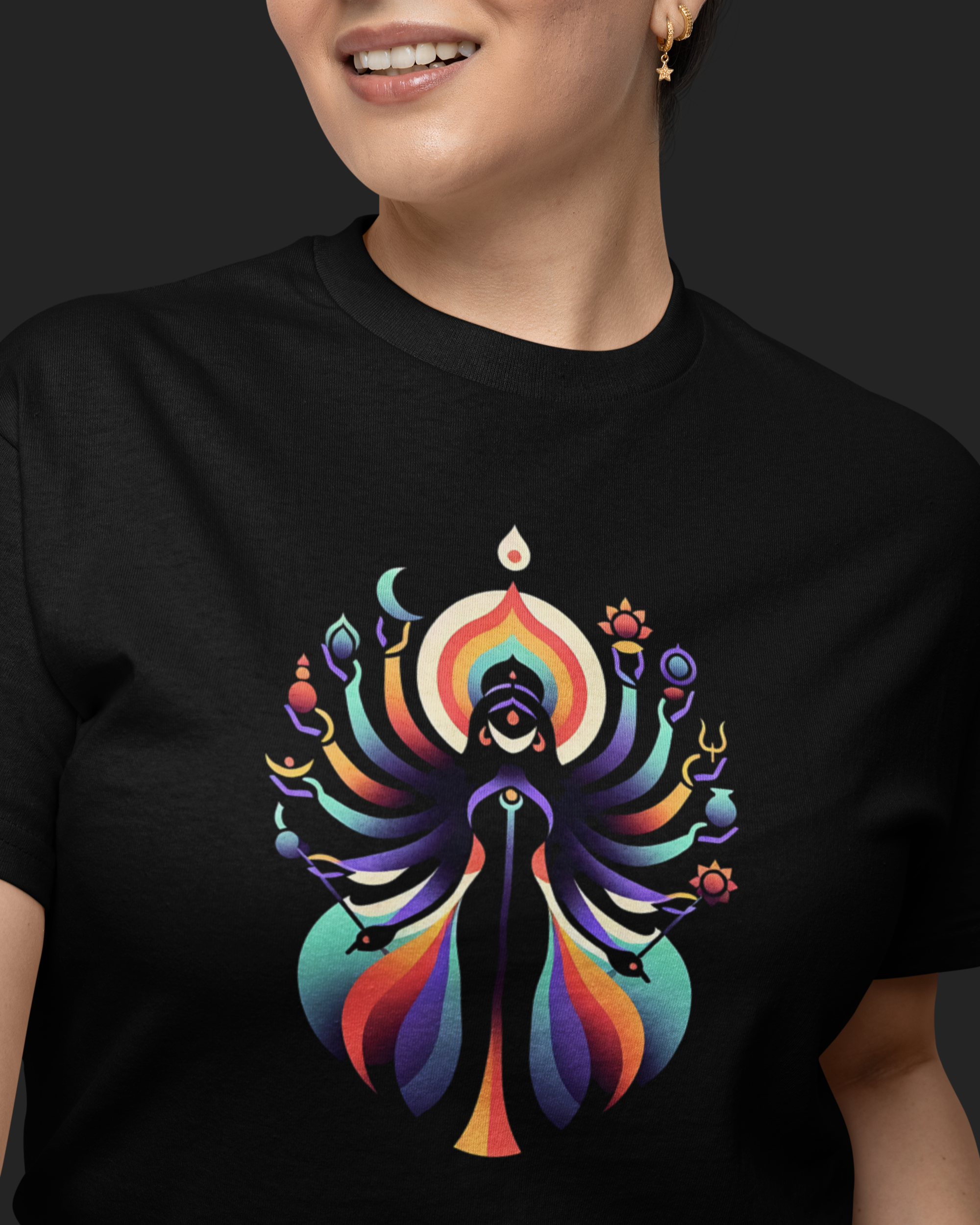Person wearing a black t-shirt with a colorful graphic design on a dark background