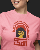 Person wearing a pink t-shirt with a graphic design on a black background