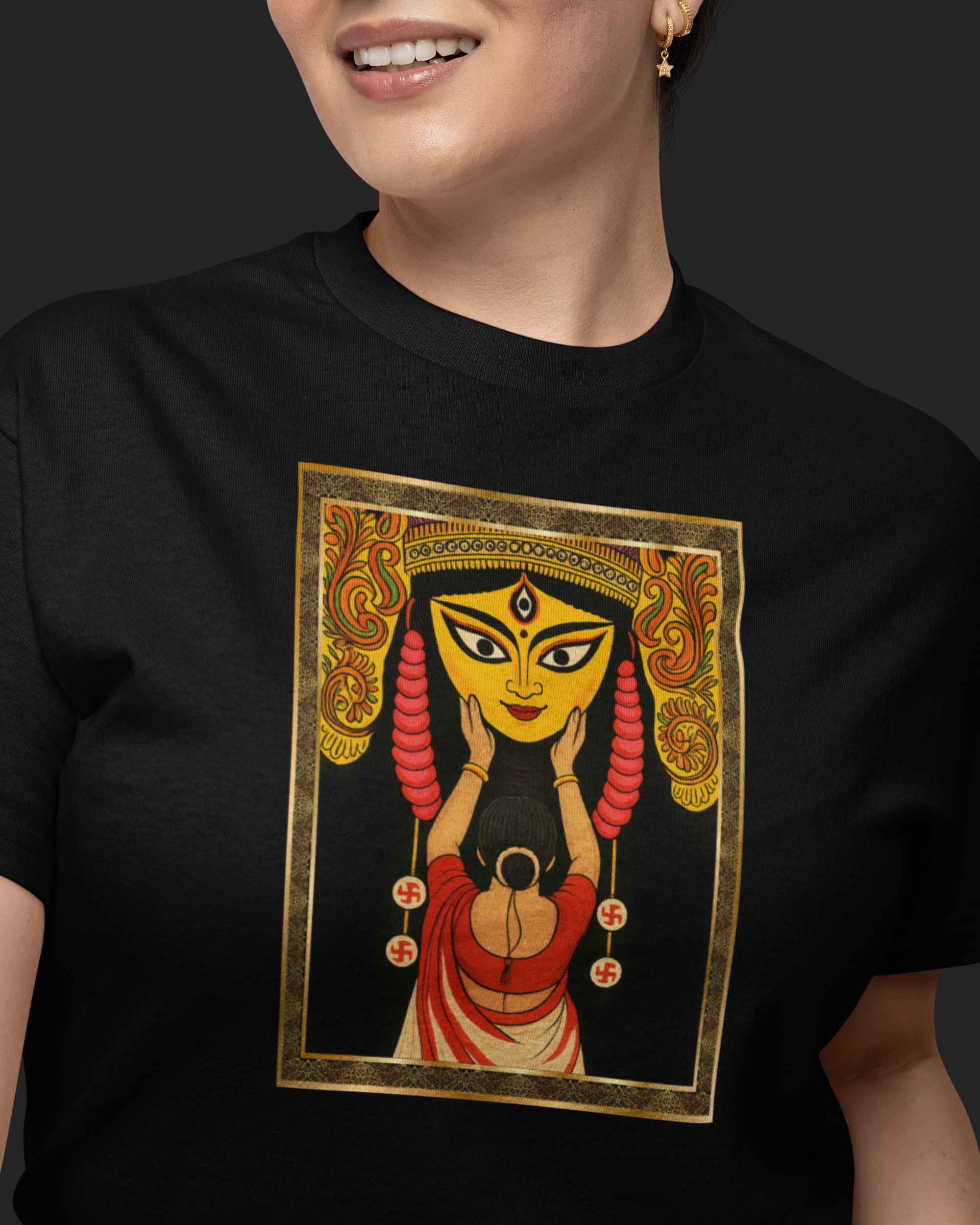 Person wearing a black t-shirt with a colorful graphic design on a dark background