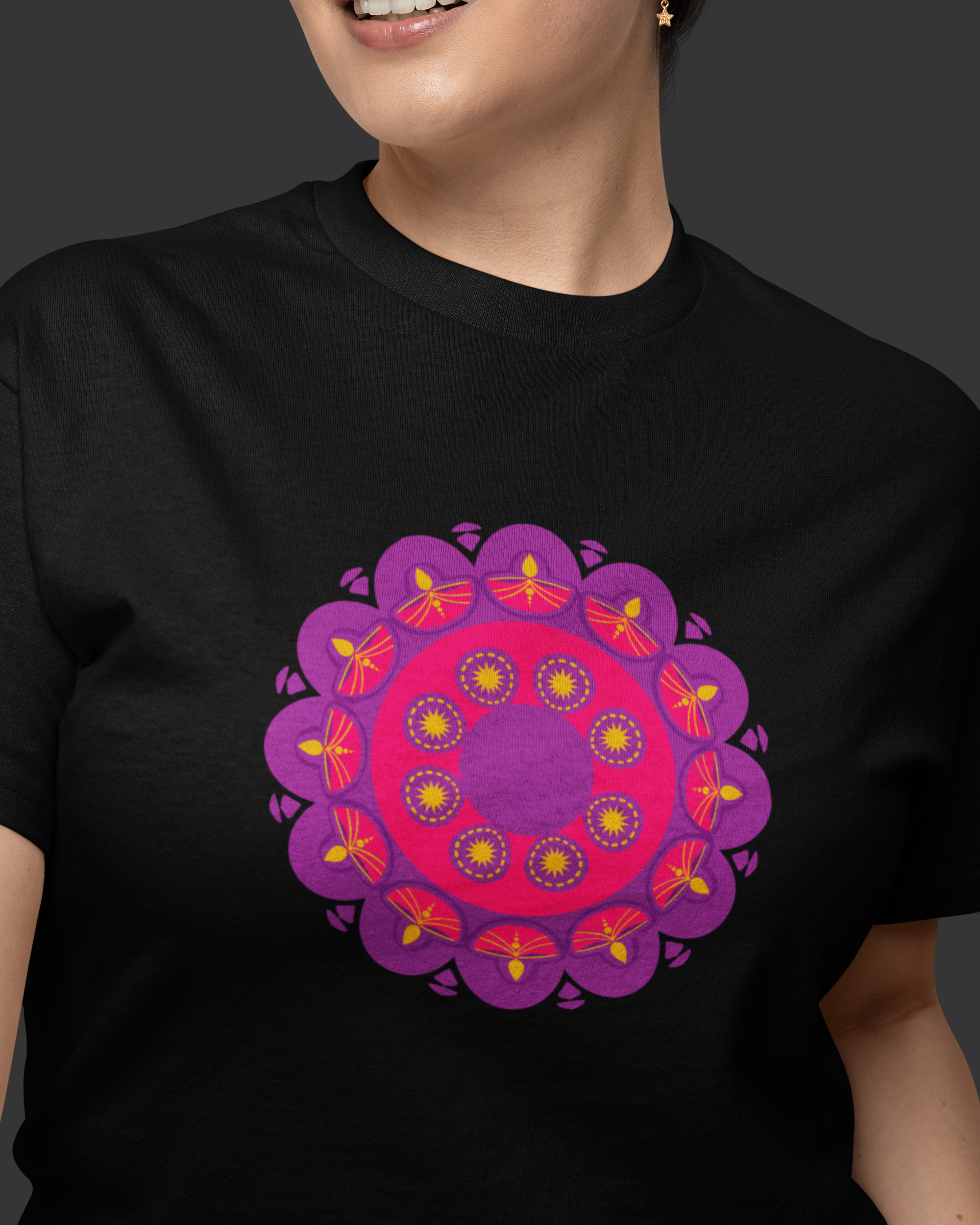 Person wearing a black t-shirt with a purple and pink mandala design on a dark background