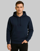 Man wearing a navy blue hoodie against a beige background