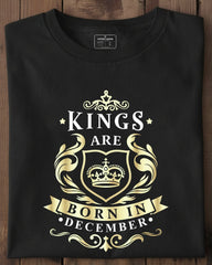 Black t-shirt with gold and white text and design on a wooden surface