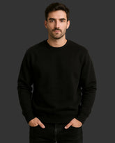 Man wearing a black sweatshirt against a dark background