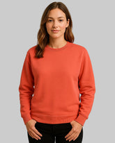 Woman wearing a red-orange sweatshirt against a plain background