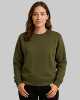 Woman wearing an olive green sweatshirt against a plain background