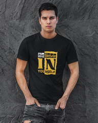 Man wearing a black t-shirt with 'Believe In Yourself' text against a gray textured background