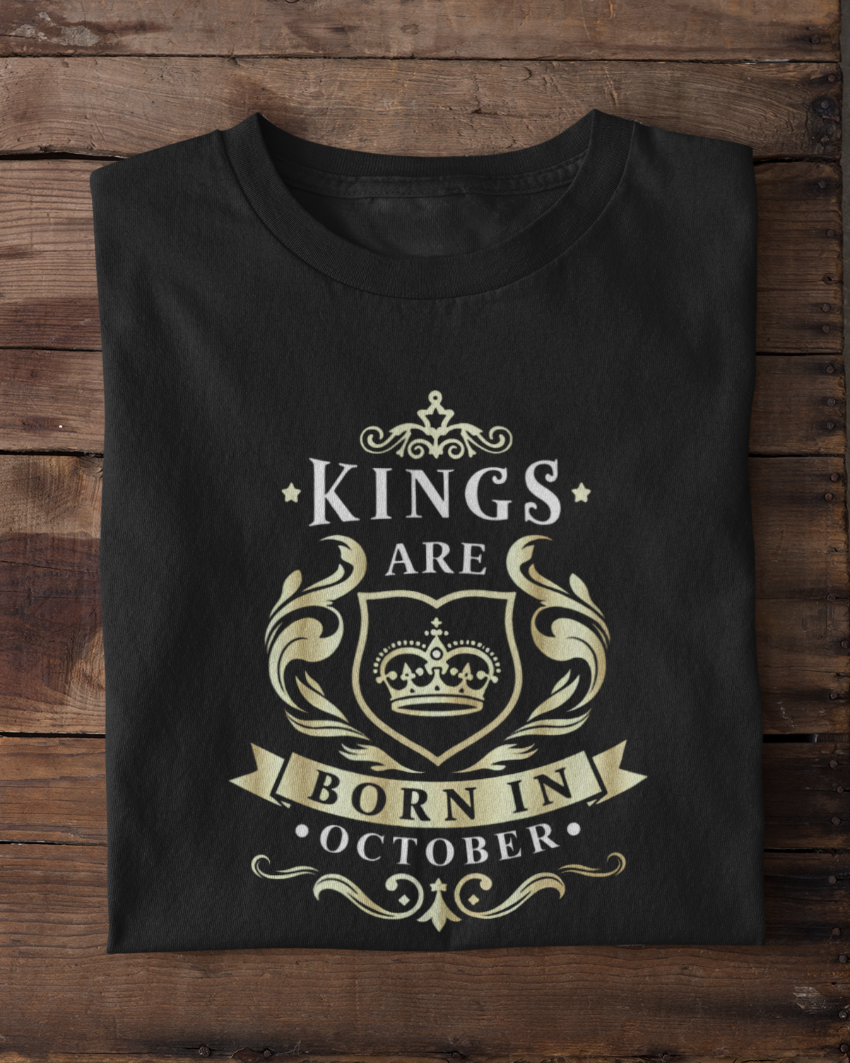 Black t-shirt with 'Kings are born in October' design on a wooden surface.