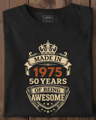Black t-shirt with 'Made in 1975, 50 years of being awesome' design on a wooden surface
