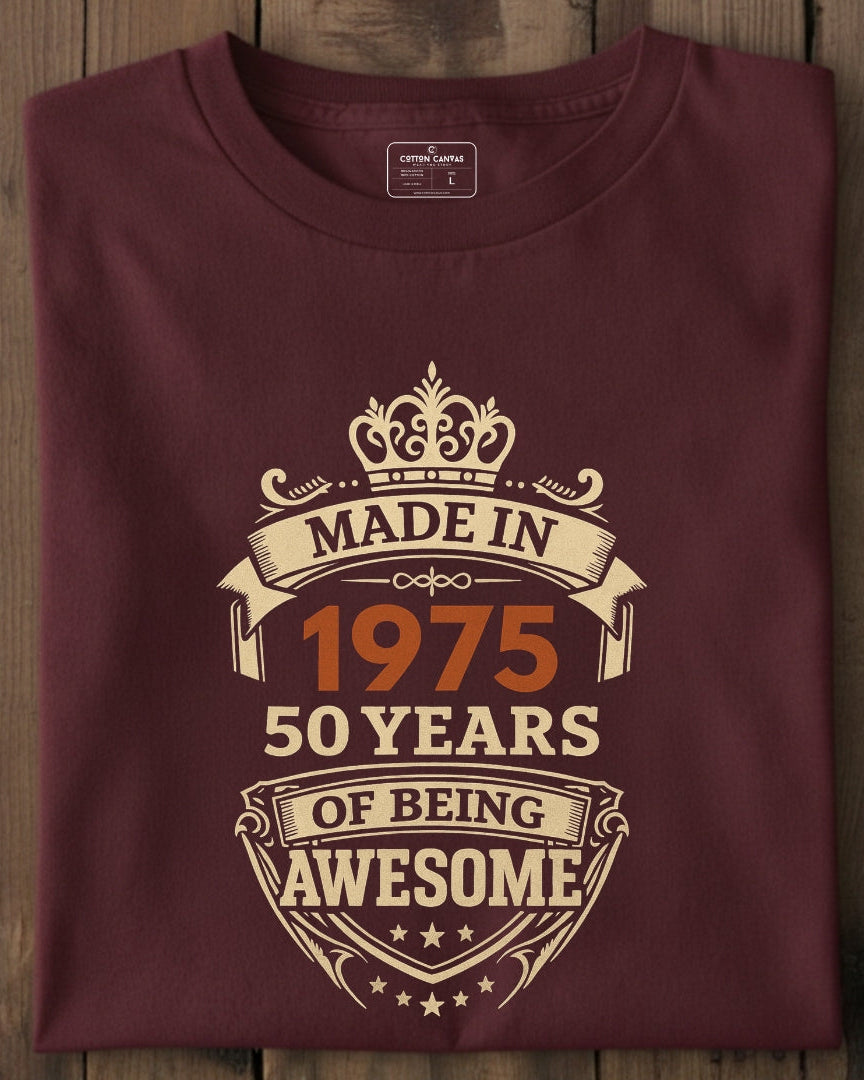 Maroon t-shirt with 'Made in 1975, 50 years of being awesome' text on a wooden surface