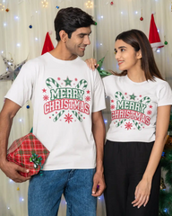 Two people wearing 'Merry Christmas' t-shirts in front of a festive background.