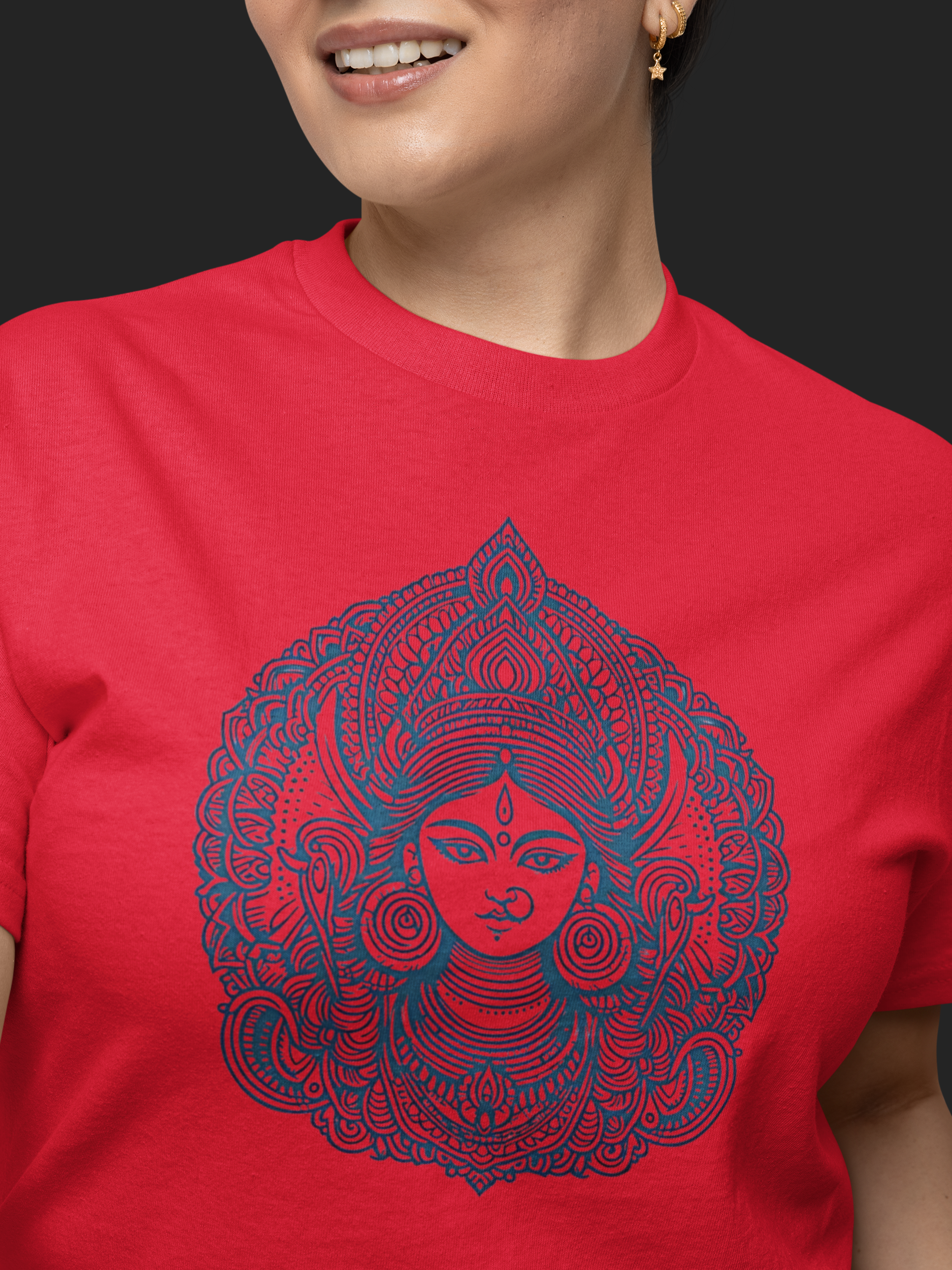 Person wearing a red t-shirt with a blue intricate design on a black background