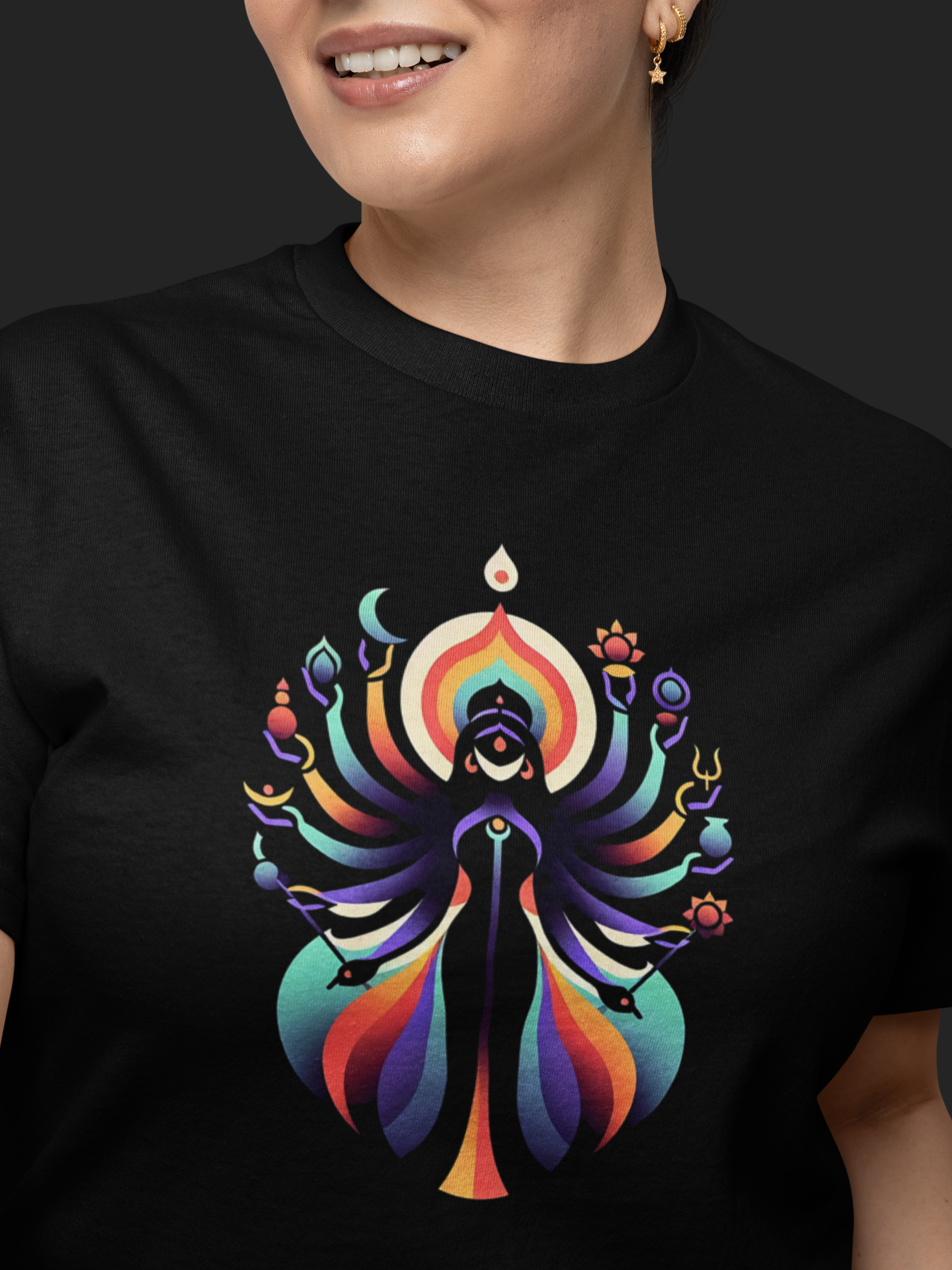 Person wearing a black t-shirt with a colorful graphic design on a dark background