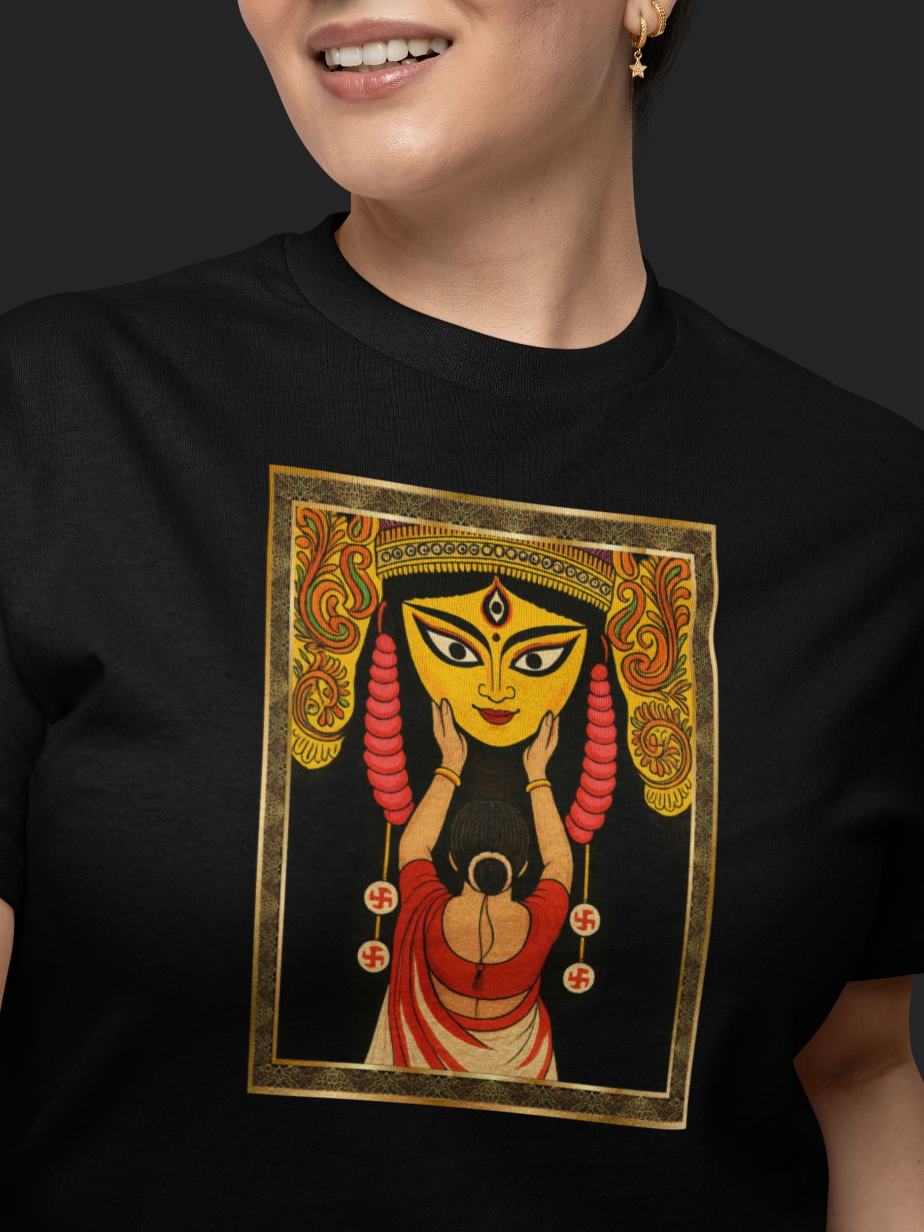 Person wearing a black t-shirt with a colorful graphic design on a dark background