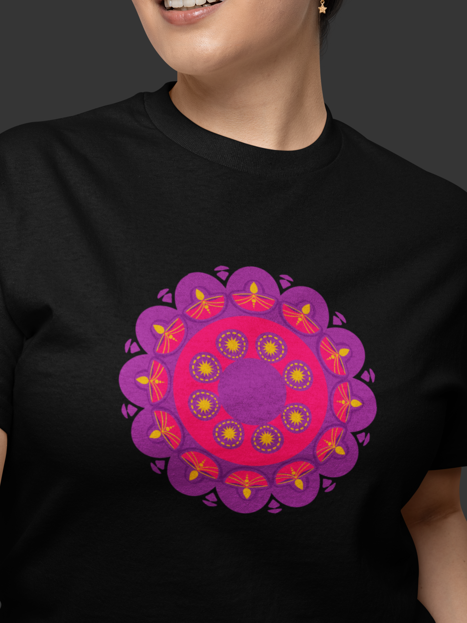 Person wearing a black t-shirt with a purple and pink mandala design on a dark background