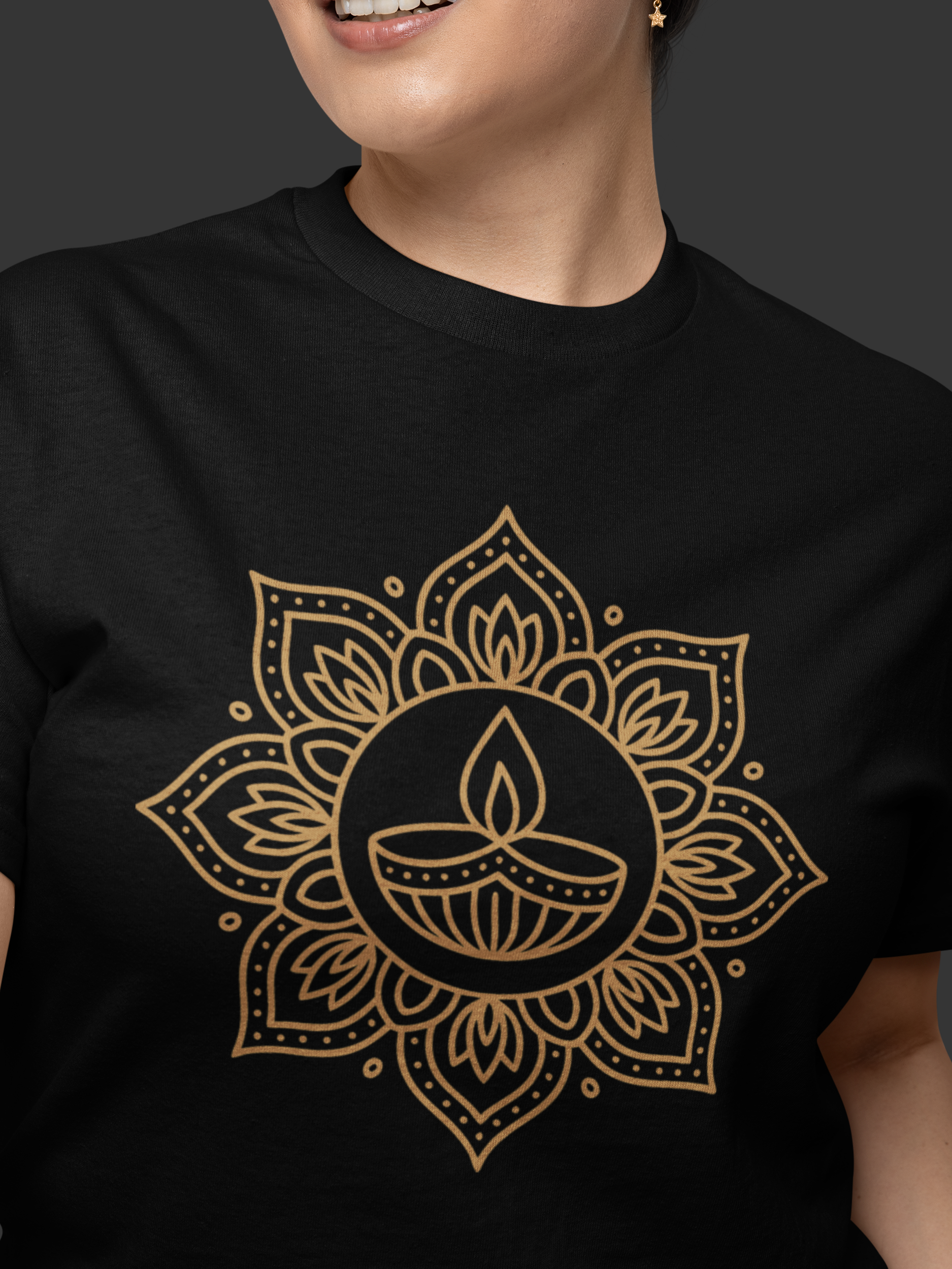 Person wearing a black t-shirt with a gold mandala design on a dark background