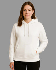 Person wearing a white hoodie against a beige background