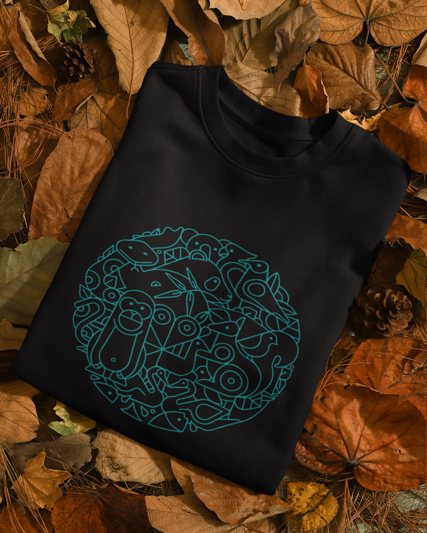 Black sleeveless shirt with blue geometric design on a bed of autumn leaves