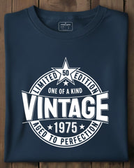 Folded navy blue t-shirt with white graphic design on a wooden surface