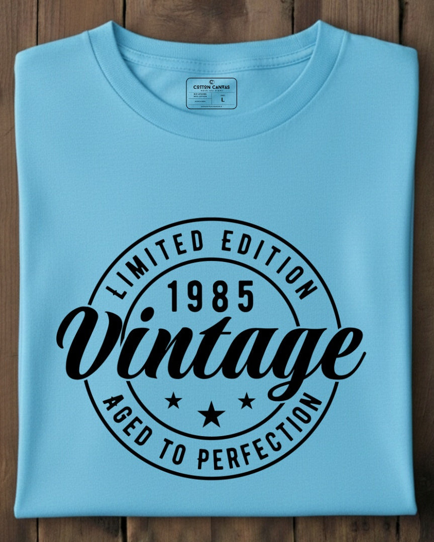 Folded light blue t-shirt with black text on a wooden surface