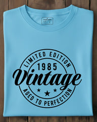 Folded light blue t-shirt with black text on a wooden surface