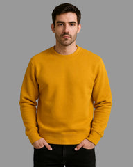 Man wearing a mustard yellow sweatshirt against a beige background