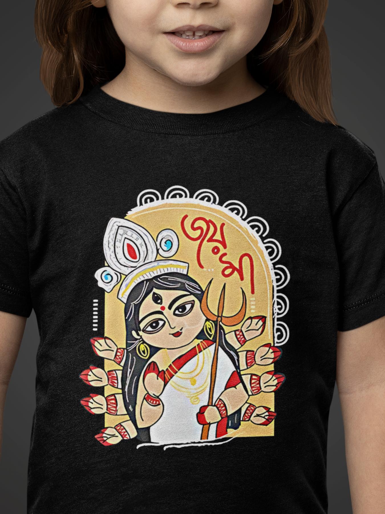 Child wearing a black t-shirt with a colorful graphic design on a dark background