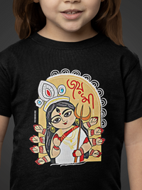 Child wearing a black t-shirt with a colorful graphic design on a dark background