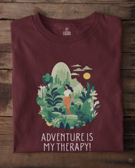 Maroon t-shirt with nature-themed design and 'Adventure is My Therapy!' text on a wooden background