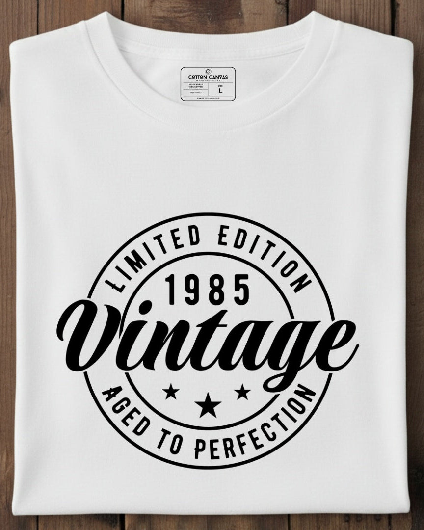 White t-shirt with black text design on a wooden surface